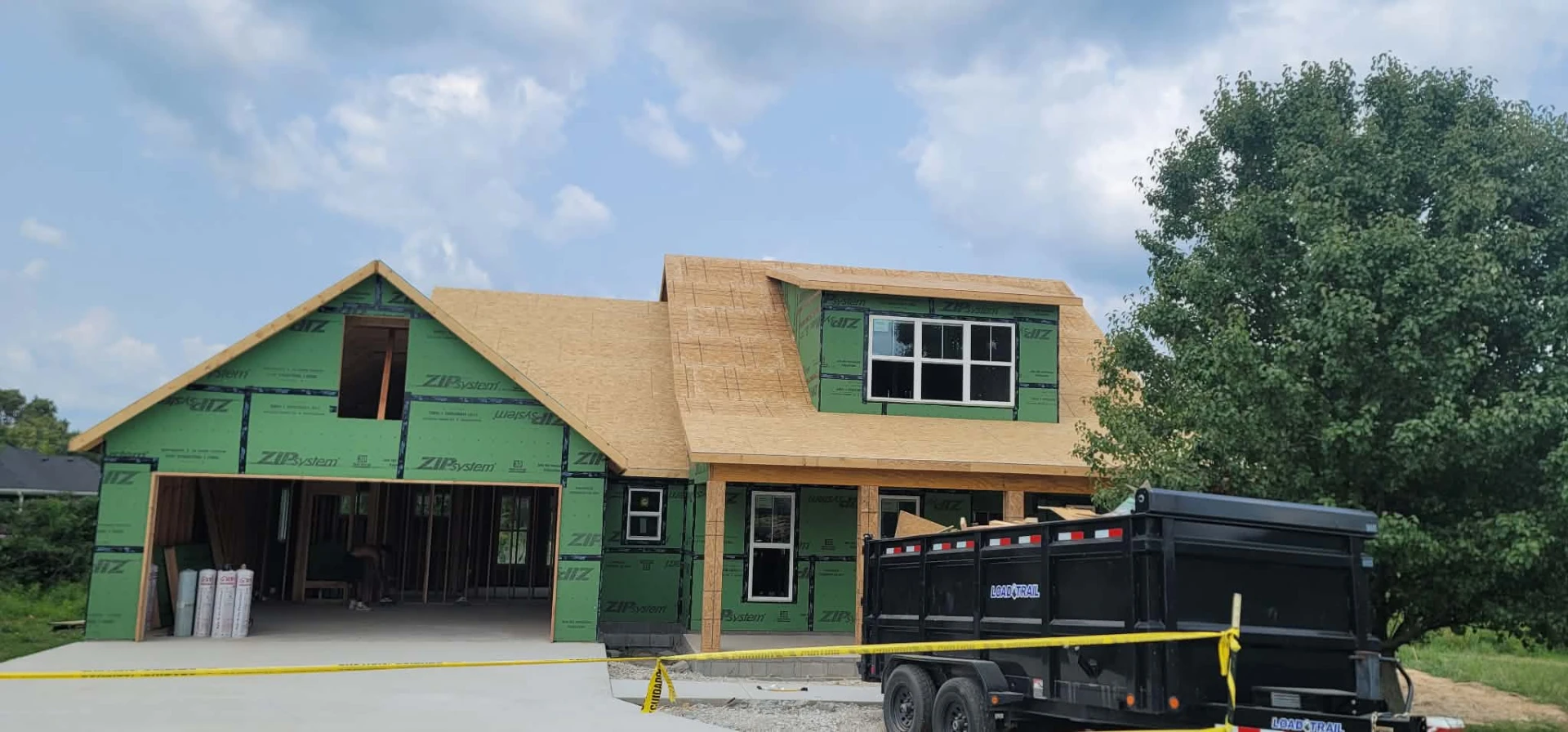 Craftsman home with dormer and attached garage during dry-in