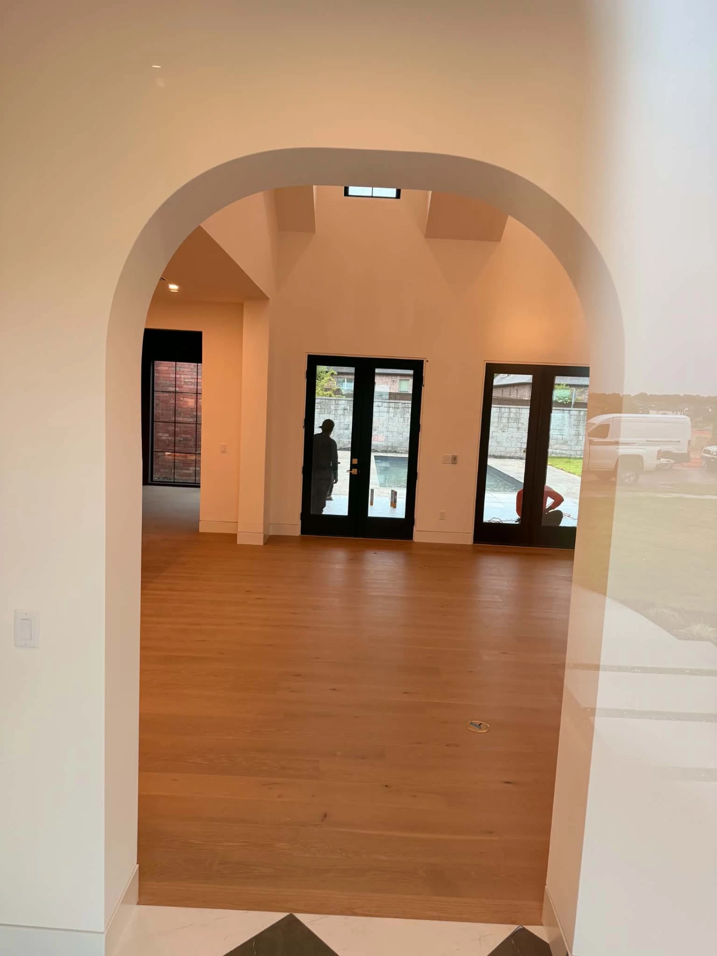 Finished interior with arched opening, white oak floors and black patio doors